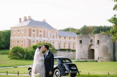 Un groupe de femmes en robes élégantes réagit avec joie face à une mariée dans une pièce décorée.