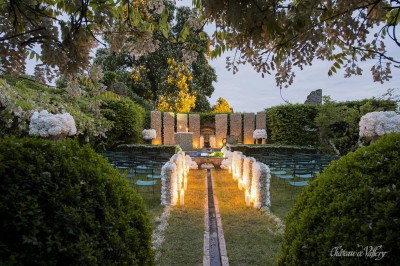 Un groupe de femmes en robes élégantes réagit avec joie face à une mariée dans une pièce décorée.