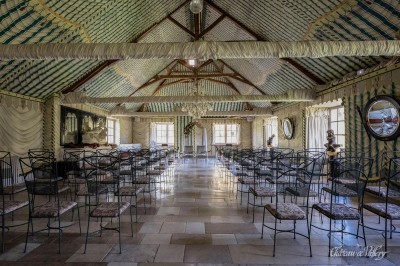Un groupe de femmes en robes élégantes réagit avec joie face à une mariée dans une pièce décorée.
