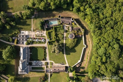 Un groupe de femmes en robes élégantes réagit avec joie face à une mariée dans une pièce décorée.