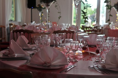 Piscine intérieure avec grandes baies vitrées donnant sur un jardin, entourée de plantes et d'une statue décorative.