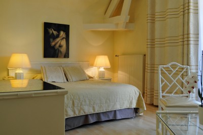 Piscine intérieure avec grandes baies vitrées donnant sur un jardin, entourée de plantes et d'une statue décorative.