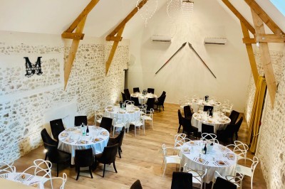 Vue aérienne d'une campagne verdoyante avec des champs, des arbres, une rivière et des habitations au loin.