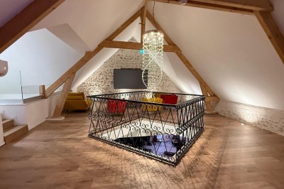 Vue aérienne d'une campagne verdoyante avec des champs, des arbres, une rivière et des habitations au loin.