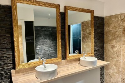 Vue aérienne d'une campagne verdoyante avec des champs, des arbres, une rivière et des habitations au loin.