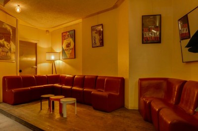 Table dressée dans un restaurant chaleureux avec planches de charcuterie, légumes, fromages, vin rouge et décor végétal.