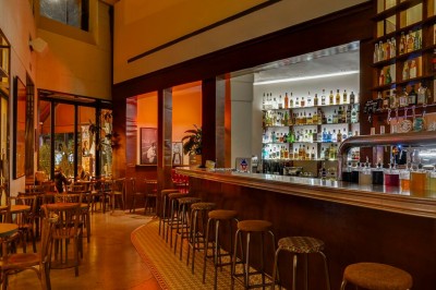 Table dressée dans un restaurant chaleureux avec planches de charcuterie, fromages, légumes et bouteilles de vin rouge.