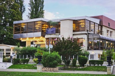 Buffet décoré avec des ballons roses et blancs, plats variés, et un cochon rôti sur une table drapée de blanc.