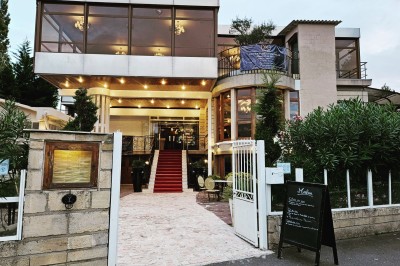 Buffet décoré avec des ballons roses et blancs, plats variés, et un cochon rôti sur une table drapée de blanc.