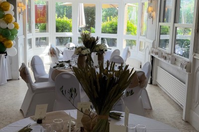 Buffet décoré avec des ballons roses et blancs, plats variés, et un cochon rôti sur une table drapée de blanc.