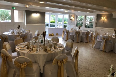 Buffet décoré avec des ballons roses et blancs, plats variés, et un cochon rôti sur une table drapée de blanc.