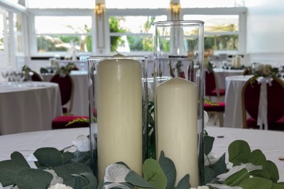 Buffet décoré avec des ballons roses et blancs, plats variés, et un cochon rôti sur une table drapée de blanc.
