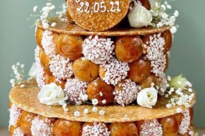 Buffet décoré avec des ballons roses et blancs, plats variés, et un cochon rôti sur une table drapée de blanc.