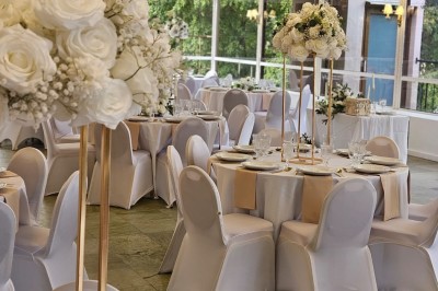 Buffet décoré avec des ballons roses et blancs, plats variés, et un cochon rôti sur une table drapée de blanc.