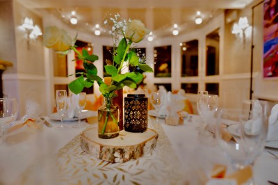 Buffet décoré avec des ballons roses et blancs, plats variés, et un cochon rôti sur une table drapée de blanc.
