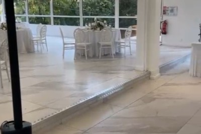 Buffet décoré avec des ballons roses et blancs, plats variés, et un cochon rôti sur une table drapée de blanc.