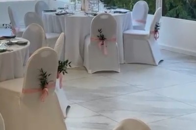Buffet décoré avec des ballons roses et blancs, plats variés, et un cochon rôti sur une table drapée de blanc.