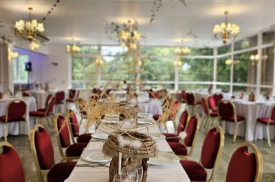 Buffet décoré avec des ballons roses et blancs, plats variés, et un cochon rôti sur une table drapée de blanc.