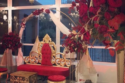 Buffet décoré avec des ballons roses et blancs, plats variés, et un cochon rôti sur une table drapée de blanc.