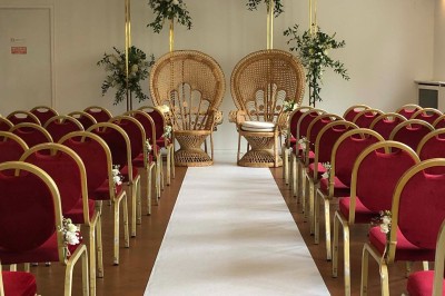 Buffet décoré avec des ballons roses et blancs, plats variés, et un cochon rôti sur une table drapée de blanc.