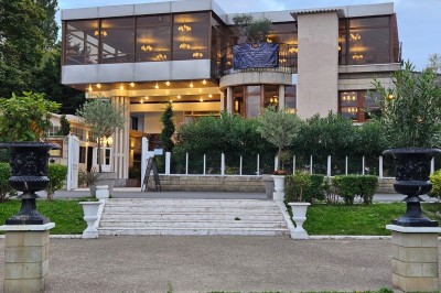 Groupe de personnes rassemblées en extérieur près d'une rivière, entourées de verdure et de stands d'exposition.