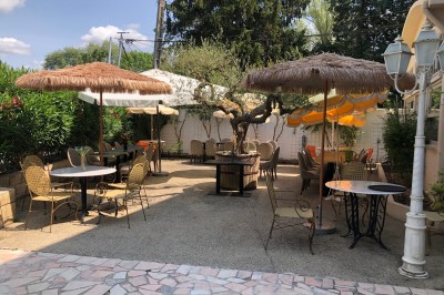 Groupe de personnes rassemblées en extérieur près d'une rivière, entourées de verdure et de stands d'exposition.
