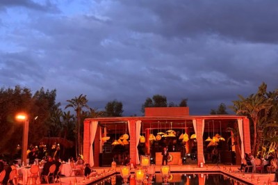 Miniature Location salle Marrakech (Province de Marrakech) - The Source #31 Reflet d'arbres et d'un bâtiment dans un bassin calme sous un ciel bleu dégagé.