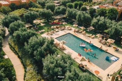 Miniature Location salle Marrakech (Province de Marrakech) - The Source #43 Reflet d'arbres et d'un bâtiment dans un bassin calme sous un ciel bleu dégagé.