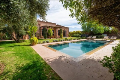 Miniature Location salle Marrakech (Province de Marrakech) - The Source #58 Reflet d'arbres et d'un bâtiment dans un bassin calme sous un ciel bleu dégagé.