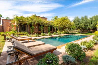 Miniature Location salle Marrakech (Province de Marrakech) - The Source #75 Reflet d'arbres et d'un bâtiment dans un bassin calme sous un ciel bleu dégagé.