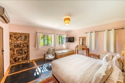 Miniature Location salle Marrakech (Province de Marrakech) - The Source #128 Reflet d'arbres et d'un bâtiment dans un bassin calme sous un ciel bleu dégagé.