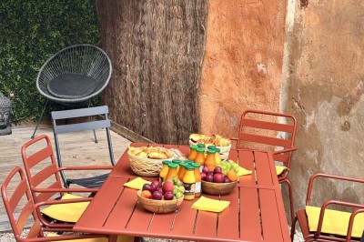 Une femme travaille sur un ordinateur dans un bureau moderne avec un mur décoré de motifs végétaux.