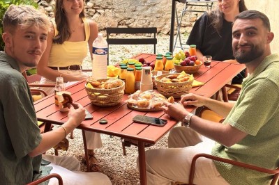 Une femme travaille sur un ordinateur dans un bureau moderne avec un mur décoré de motifs végétaux.