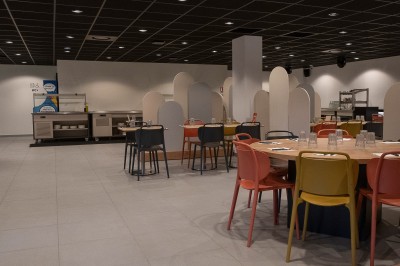 Miniature Location salle Marines (Val-d'Oise) - Stand Ing Events #7 Salle moderne avec tables hautes, éclairage tamisé, et mur décoré d'une scène urbaine nocturne avec un bistrot.