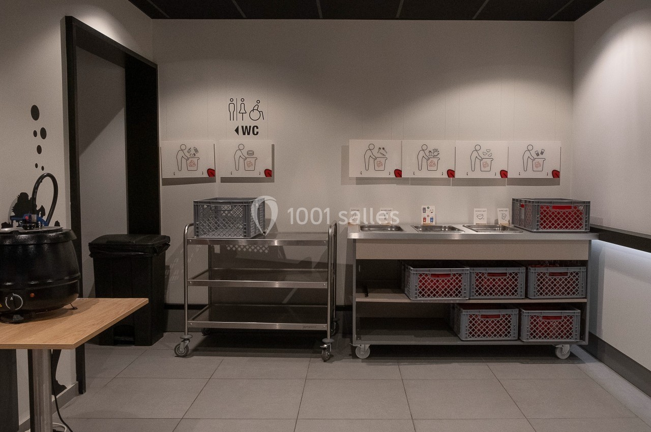 Location salle Marines (Val-d'Oise) - Stand Ing Events #10 Espace de tri des déchets avec bacs de recyclage et affiches explicatives sur un mur dans un environnement intérieur.