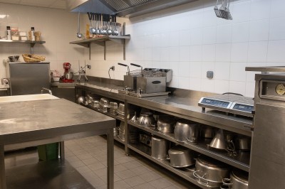Salle de bain moderne avec lavabo, miroir rond, mur en carrelage noir et blanc, et éclairage tamisé.