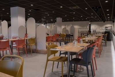 Salle de bain moderne avec lavabo, miroir rond, mur en carrelage noir et blanc, et éclairage tamisé.