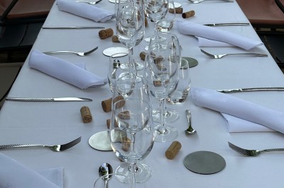 Salle décorée pour les fêtes avec guirlandes lumineuses, table rouge ornée de bougies et mini sapins, scène en arrière-plan.