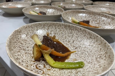 Assiette gastronomique avec foie gras, asperges, pain brioché et garnitures colorées, dressée pour un service en série.