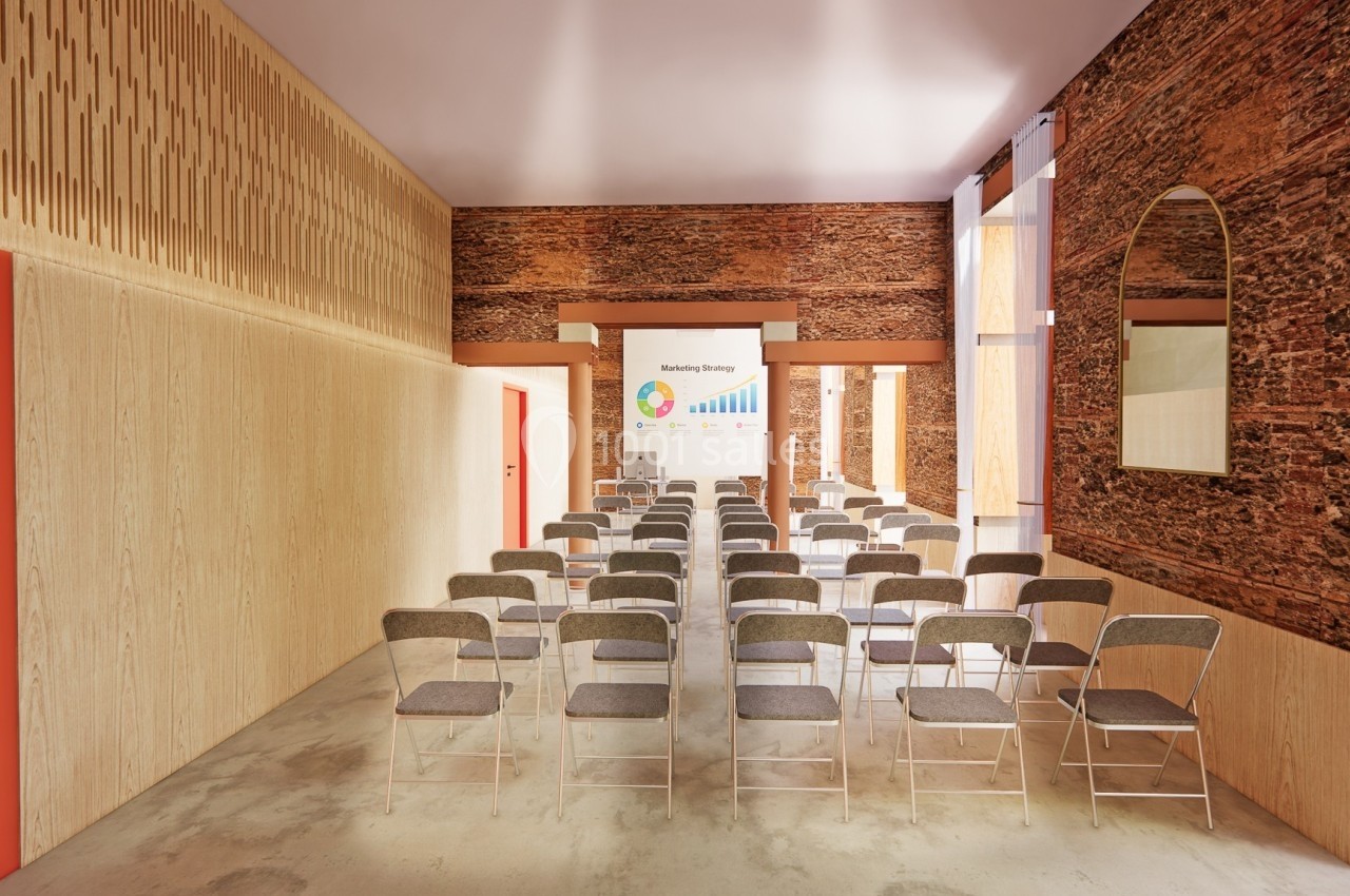 Salle de conférence lumineuse avec des rangées de chaises pliantes face à un écran affichant un graphique coloré.