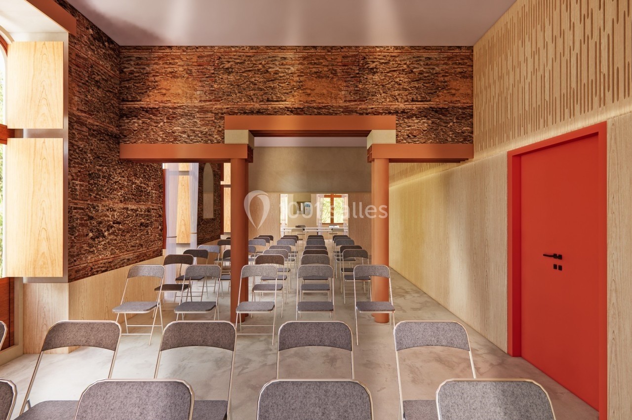 Salle lumineuse avec des rangées de chaises grises, murs en bois texturé et porte rouge sur le côté droit.