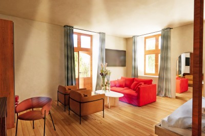 Vue aérienne d'un château en briques rouges entouré de pelouses bien entretenues et d'arbres.