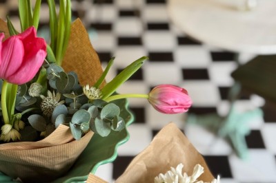 Fauteuil bleu et table basse dans un salon au style vintage avec papier peint fleuri et armoire en bois.
