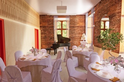 Vue aérienne d'un château en briques rouges entouré d'une pelouse bien entretenue et d'arbres.