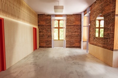 Vue aérienne d'un château en briques rouges entouré d'une pelouse bien entretenue et d'arbres.