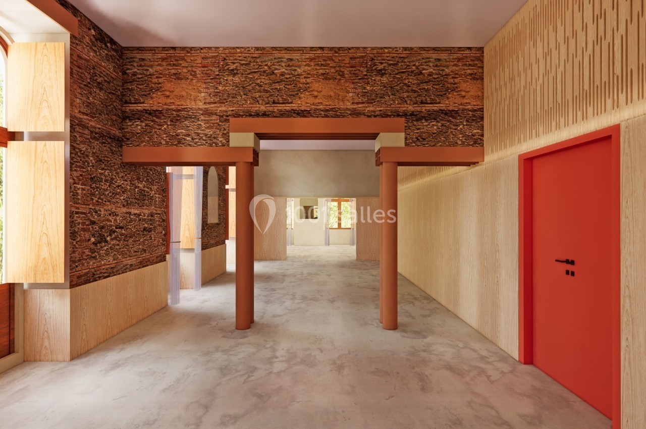 Intérieur lumineux avec murs en bois texturés, porte rouge et grandes fenêtres donnant sur un espace verdoyant.