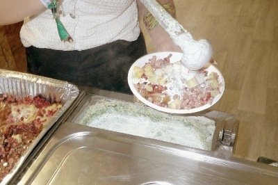 File d'attente devant un food truck avec des clients commandant et un cuisinier préparant des plats.