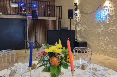 Tables et chaises installées en extérieur près d'une piscine, avec des stands et des arbres en arrière-plan.