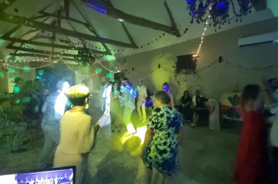 Tables et chaises installées en extérieur près d'une piscine, avec des stands et des arbres en arrière-plan.