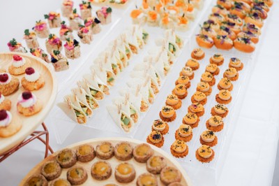 Plateau de petits fours variés disposés sur des présentoirs lors d'un buffet.